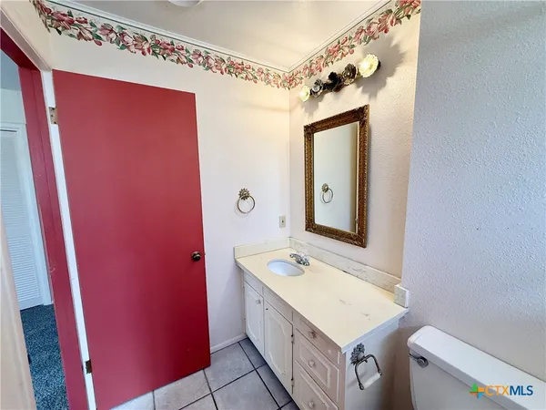 a bathroom with a sink a toilet a mirror and vanity