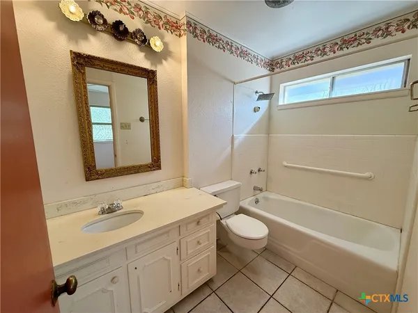 a bathroom with a granite countertop sink a toilet and shower