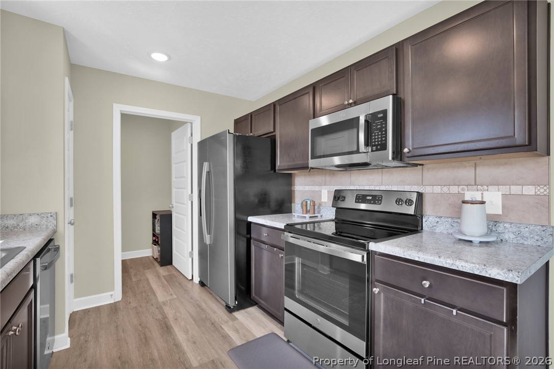 351 Sandy Grove Road Parkton, NC 28371 - Photo 12 of 30 a kitchen with stainless steel appliances granite countertop a stove microwave and refrigerator