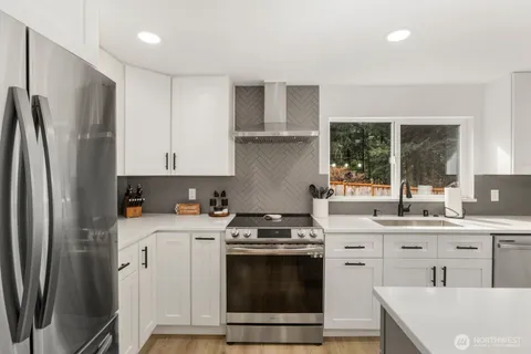 a kitchen with stainless steel appliances a stove a sink and a refrigerator