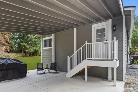 a view of a chair and table in backyard of the house