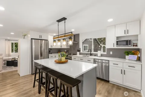 a kitchen with a sink a stove a refrigerator and cabinets