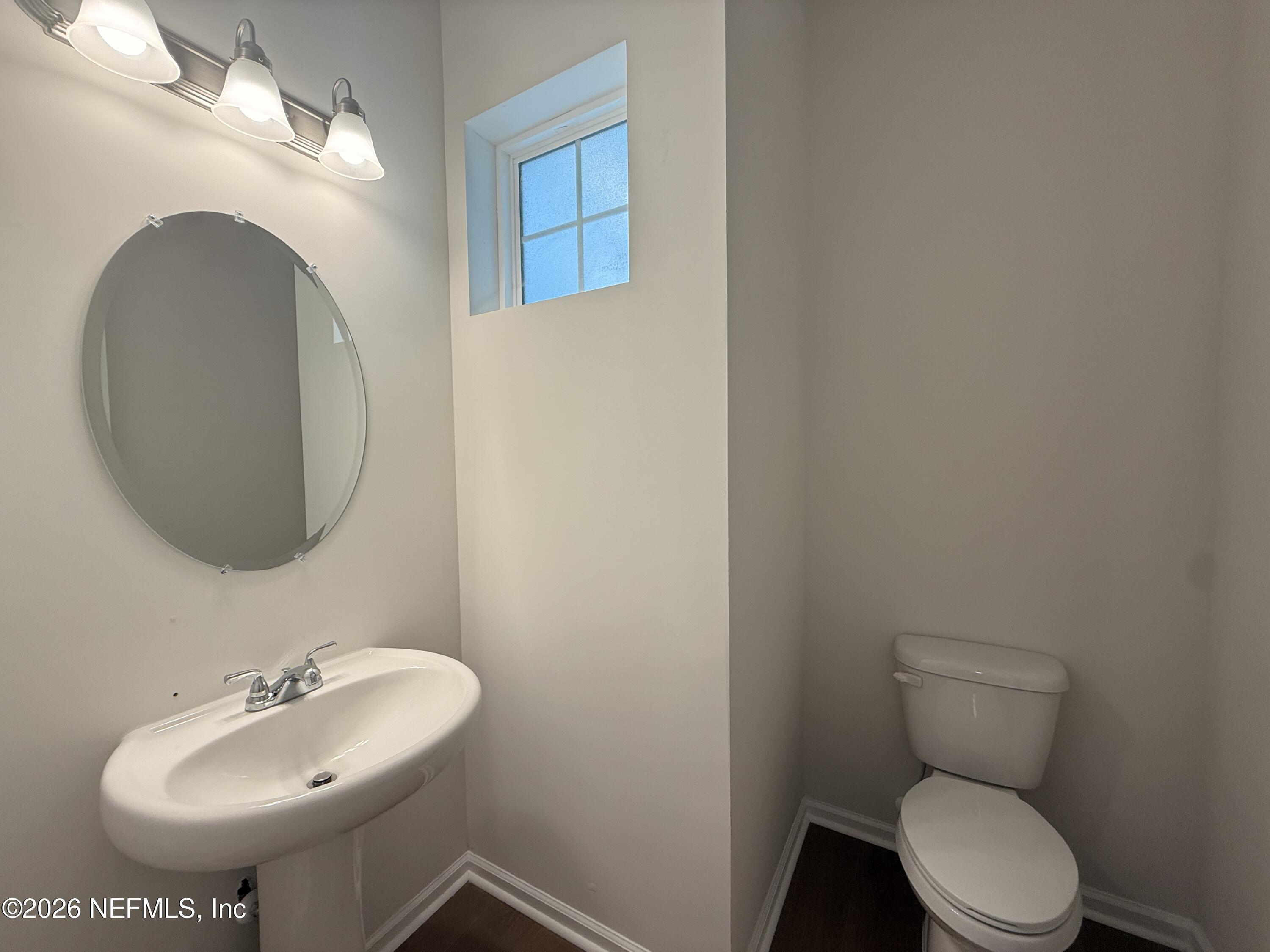 95110 Barnwell Road Fernandina Beach, FL 32034 - Photo 13 of 22 a bathroom with a toilet sink and mirror
