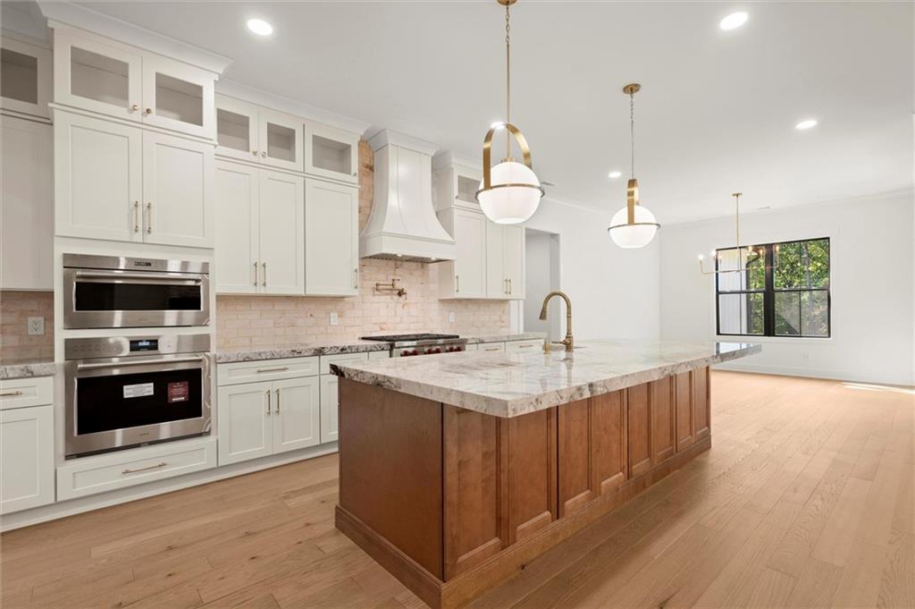 145 Highlands Chase Ball Ground, GA 30107 - Photo 19 of 79 a kitchen with stainless steel appliances granite countertop a stove a sink and a wooden floors