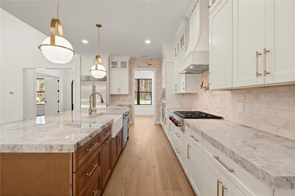 145 Highlands Chase Ball Ground, GA 30107 - Photo 24 of 79 a large kitchen with stainless steel appliances granite countertop a lot of counter space and wooden floor