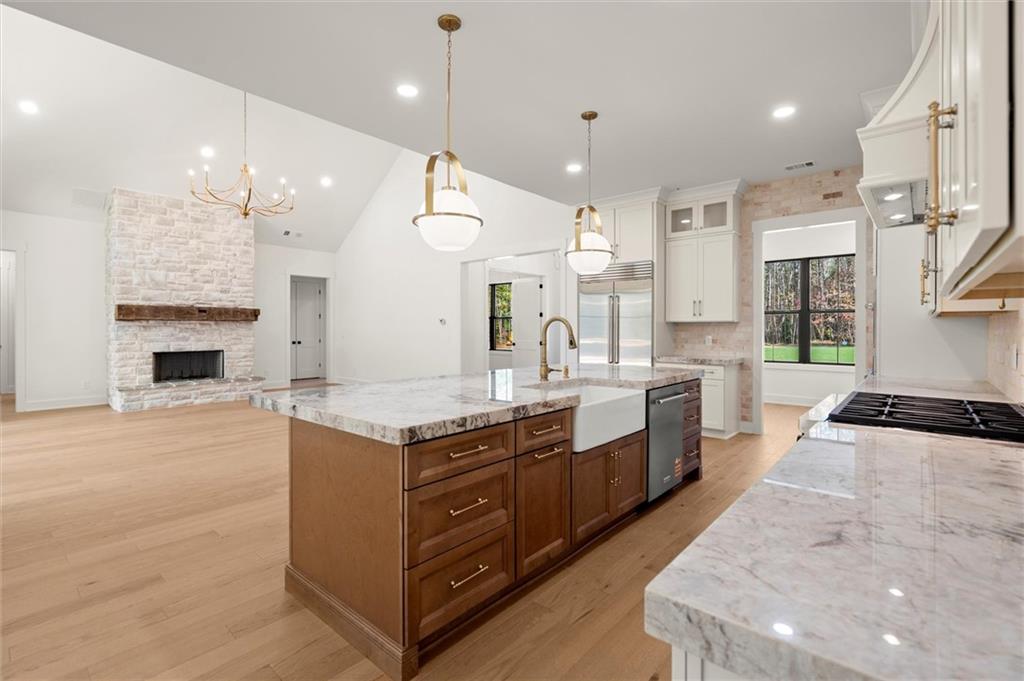 145 Highlands Chase Ball Ground, GA 30107 - Photo 26 of 79 a large kitchen with stainless steel appliances granite countertop a stove a sink and a refrigerator
