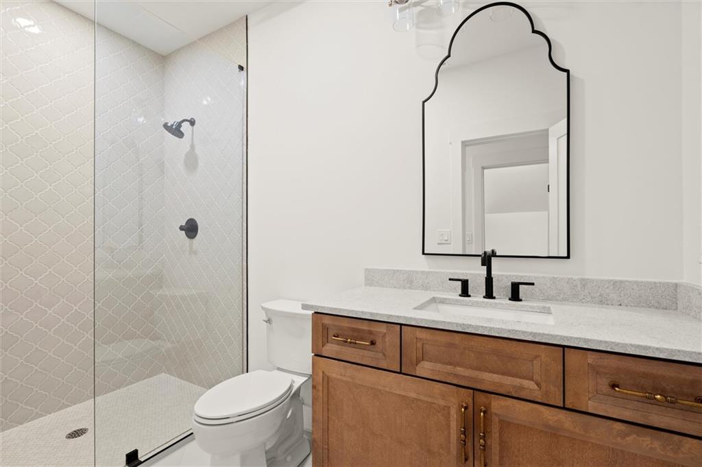 145 Highlands Chase Ball Ground, GA 30107 - Photo 42 of 79 a bathroom with a granite countertop sink a toilet and a mirror