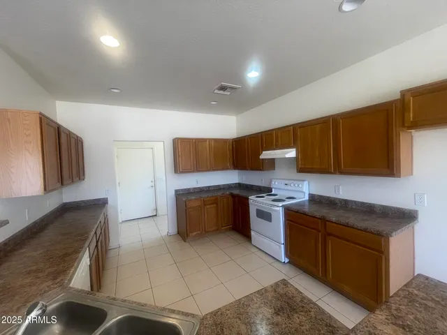 a kitchen with a sink a counter top space and cabinets