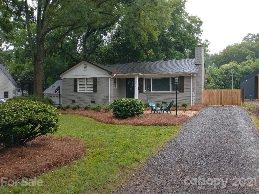a view of a house with a yard and potted plants