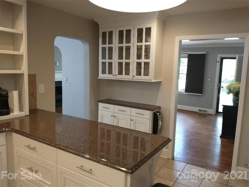 3634 Park Road Charlotte, NC 28209 - Photo 6 of 15 a kitchen with stainless steel appliances granite countertop a stove and a microwave with wooden floor
