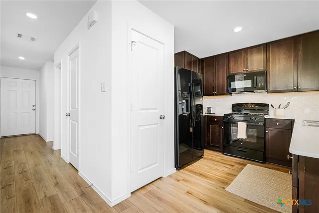 a kitchen with stainless steel appliances a sink stove and cabinets