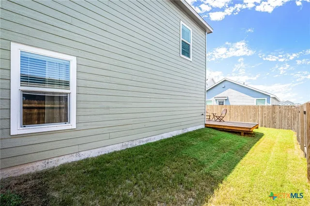 a view of a backyard with a wooden fence