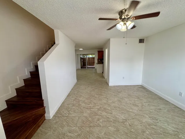 wooden floor in an empty room with a chandelier