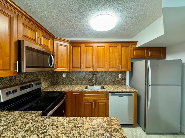 a kitchen with a refrigerator stove and sink