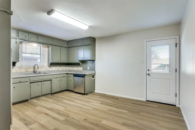 a kitchen with granite countertop a sink cabinets and wooden floor