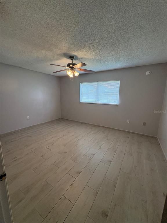 4027 Bianca Street Sebring, FL 33872 - Photo 6 of 22 en empty room with windows and chandelier fan