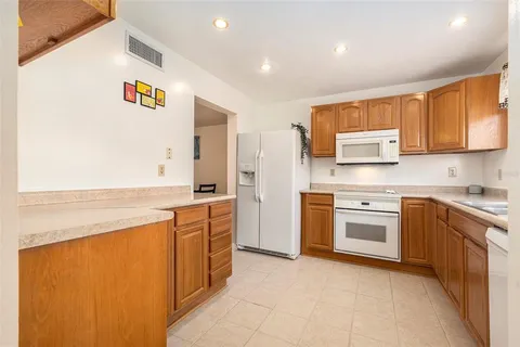 a large kitchen with stainless steel appliances granite countertop a stove a sink and a refrigerator