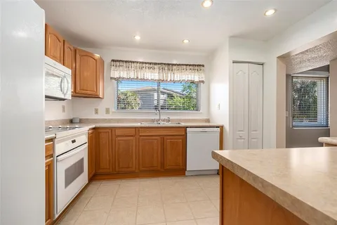 a kitchen with stainless steel appliances granite countertop a stove a sink and a refrigerator
