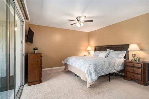 a bedroom with a bed a flat screen tv and a chandelier