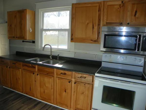 a kitchen with granite countertop cabinets stainless steel appliances and a sink