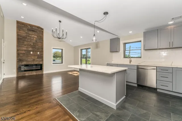 a kitchen with granite countertop a refrigerator and a sink