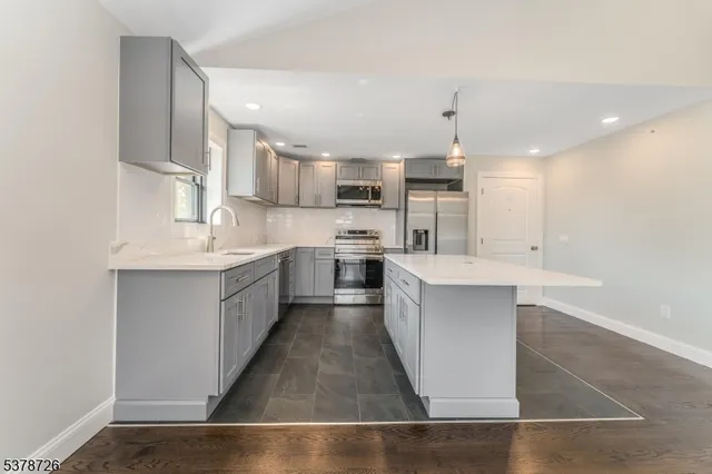 a view of a kitchen with a sink stainless steel appliances and cabinets