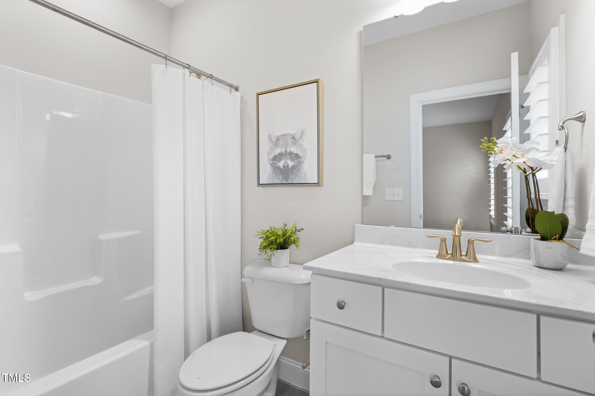 1013 Manchaca Loop Apex, NC 27539 - Photo 32 of 50 a bathroom with a sink mirror vanity and toilet