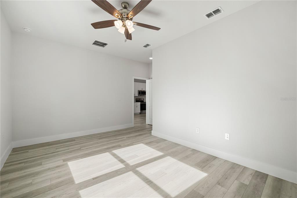 16054 Southwest 29th Court Road Ocala, FL 34473 - Photo 14 of 27 an empty room with a ceiling fan and wooden floor