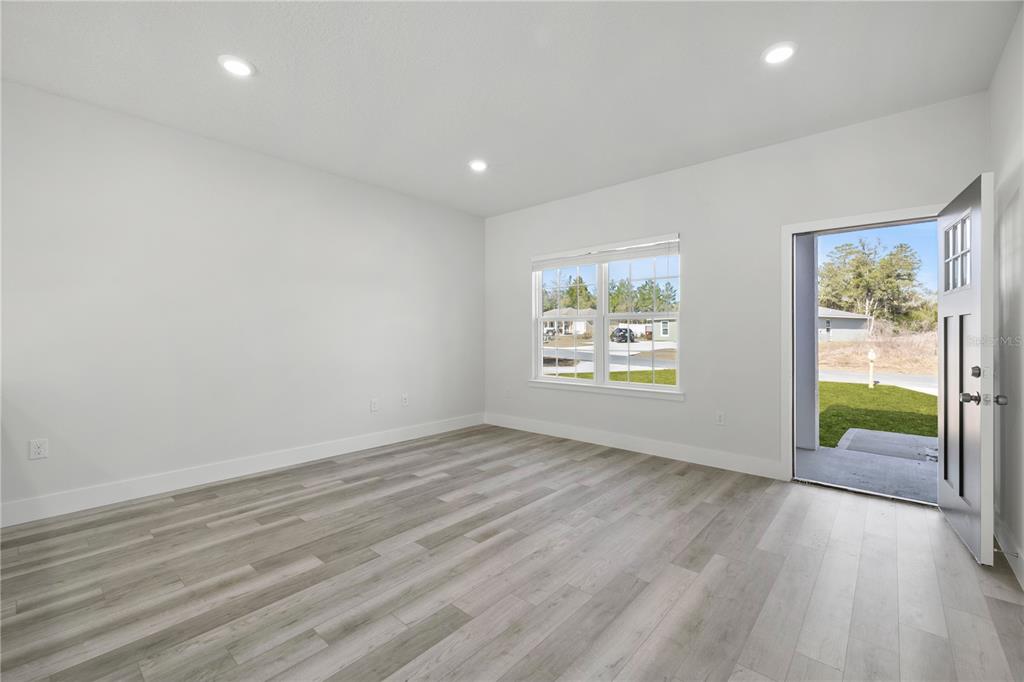 16054 Southwest 29th Court Road Ocala, FL 34473 - Photo 2 of 27 an empty room with wooden floor and windows