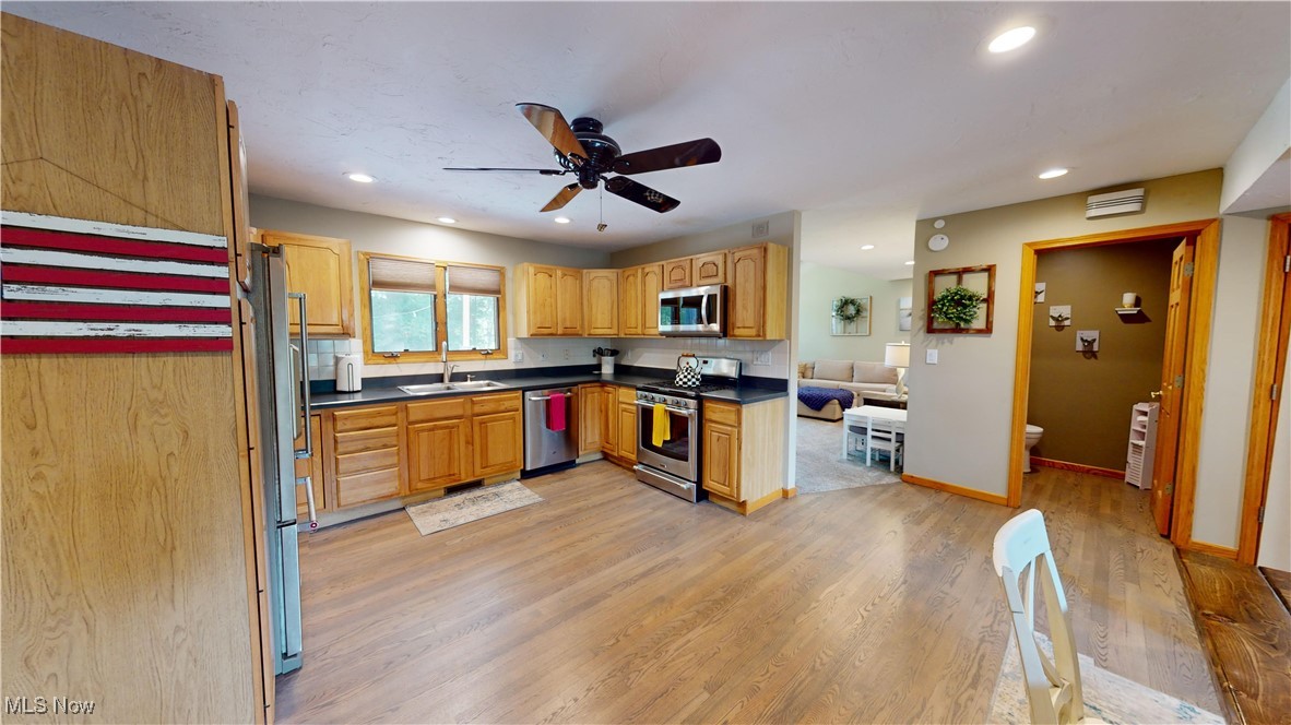 571 Ledge Road Macedonia, OH 44056 - Photo 10 of 35 Kitchen with ceiling fan, stainless steel appliances, sink, light hardwood / wood-style floors, and backsplash