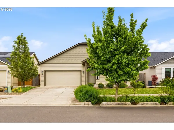 a front view of a house with a yard and a garage