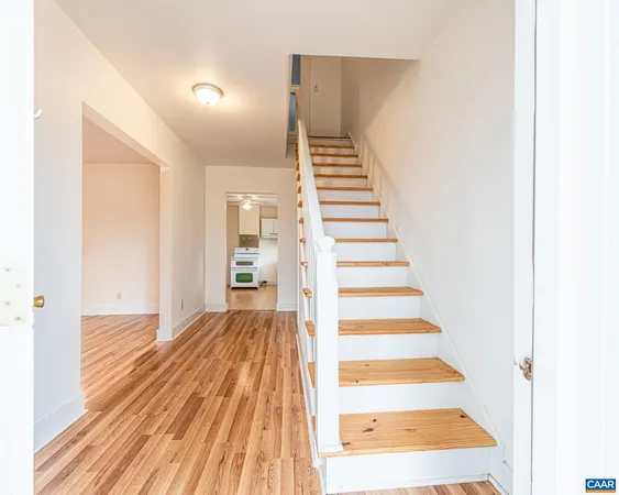 a view of a hallway with wooden floor and entryway