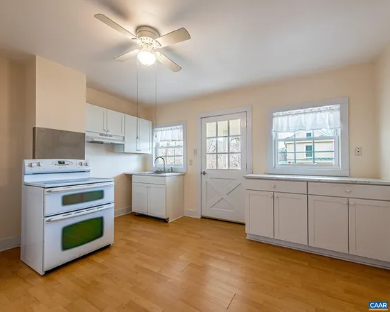 a kitchen with a stove cabinets and wooden floor