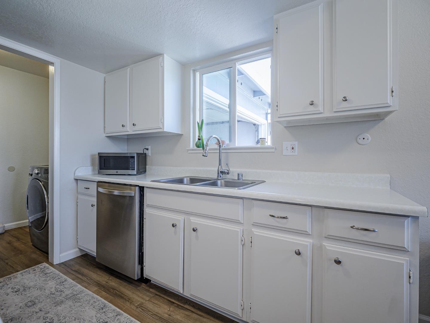569 Cedar Drive Watsonville, CA 95076 - Photo 11 of 30 a kitchen with stainless steel appliances granite countertop white cabinets a sink and dishwasher with wooden floor