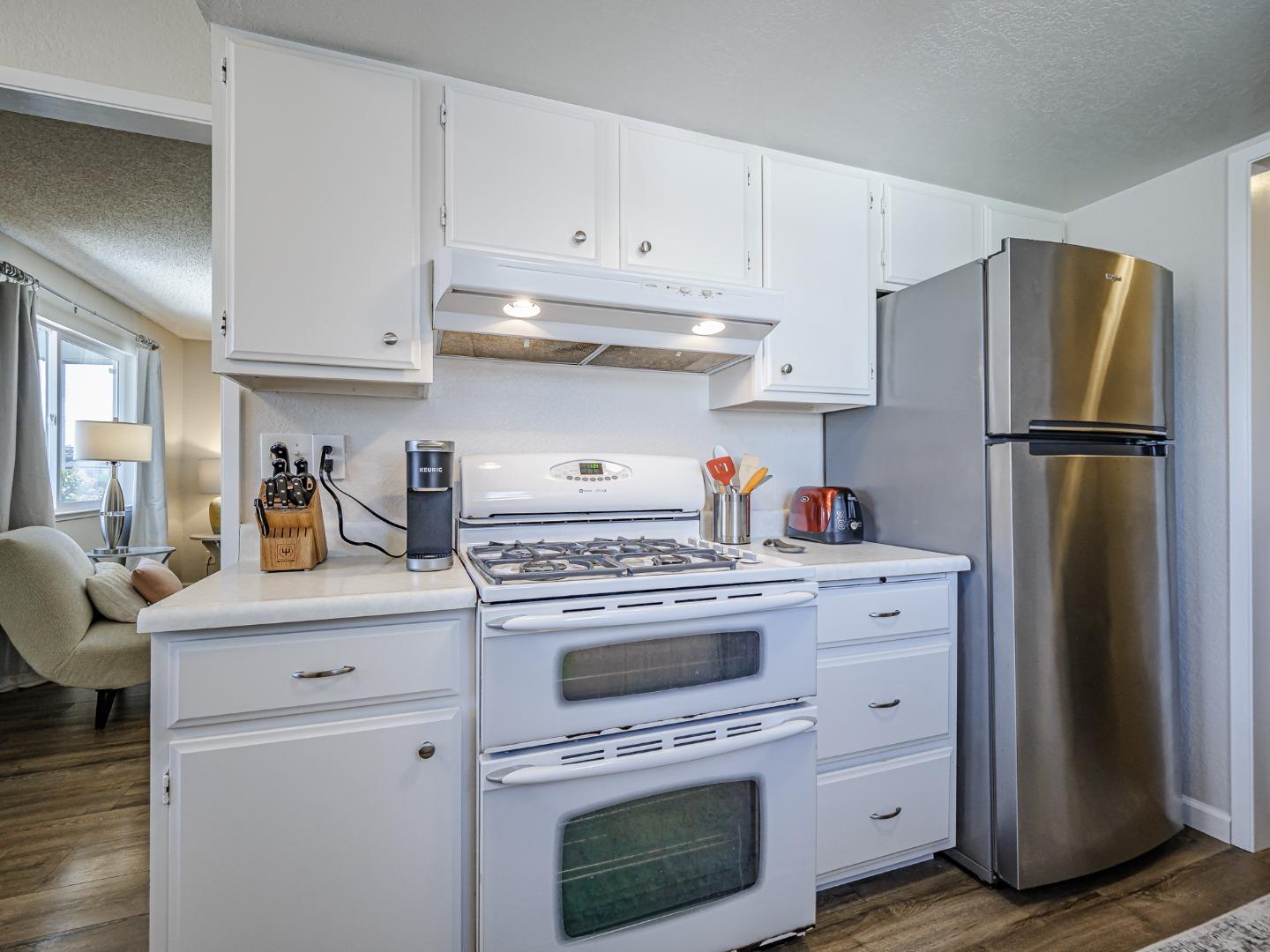 569 Cedar Drive Watsonville, CA 95076 - Photo 10 of 30 a kitchen with white cabinets and white appliances