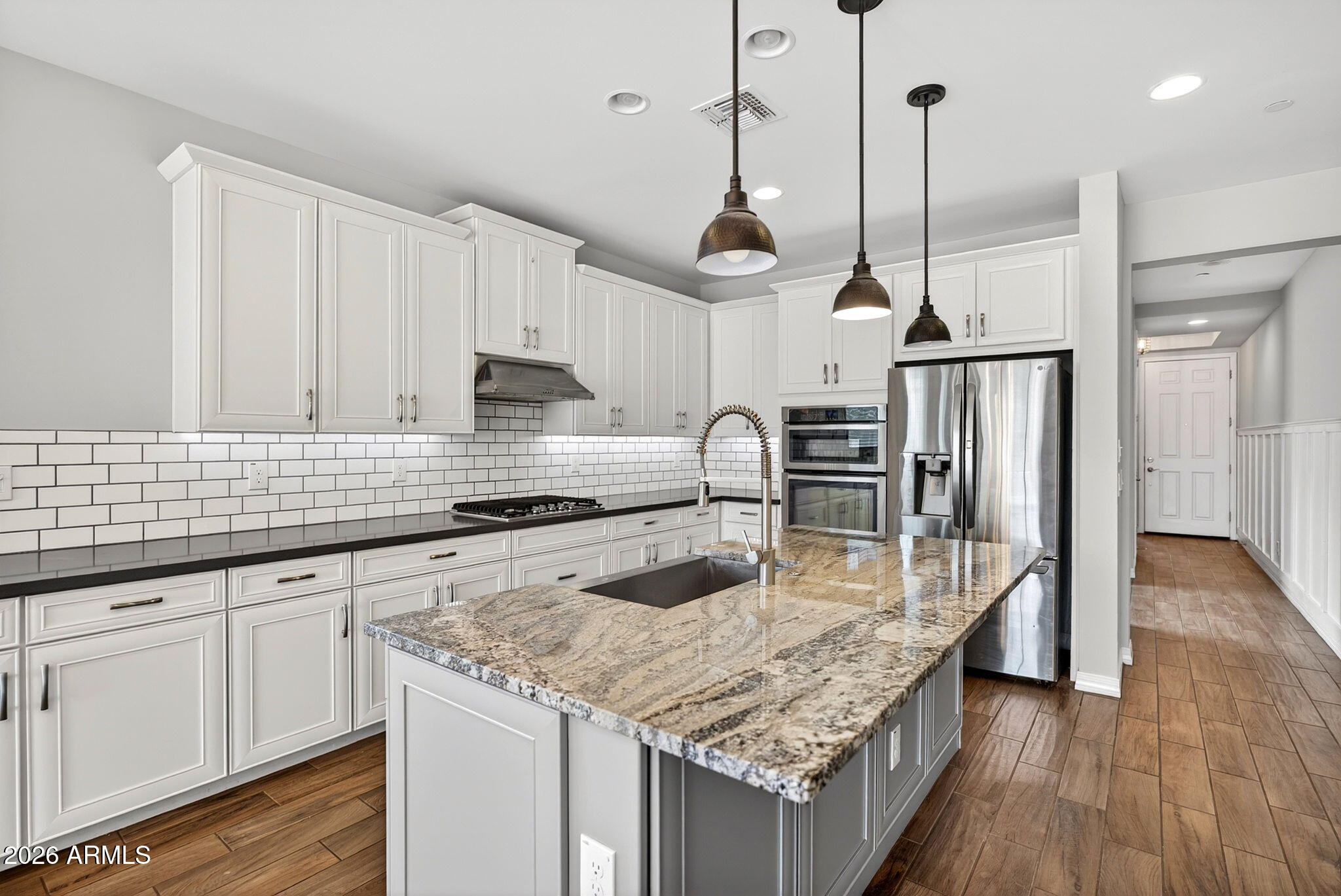 12124 West Peak View Road Peoria, AZ 85383 - Photo 6 of 38 a kitchen with stainless steel appliances granite countertop a sink a refrigerator and wooden floor