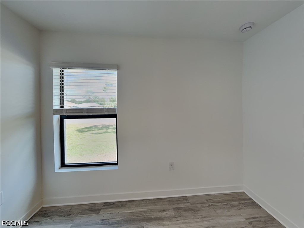 3201 23rd Street Southwest Lehigh Acres, FL 33976 - Photo 11 of 15 a view of an empty room with wooden floor and a window