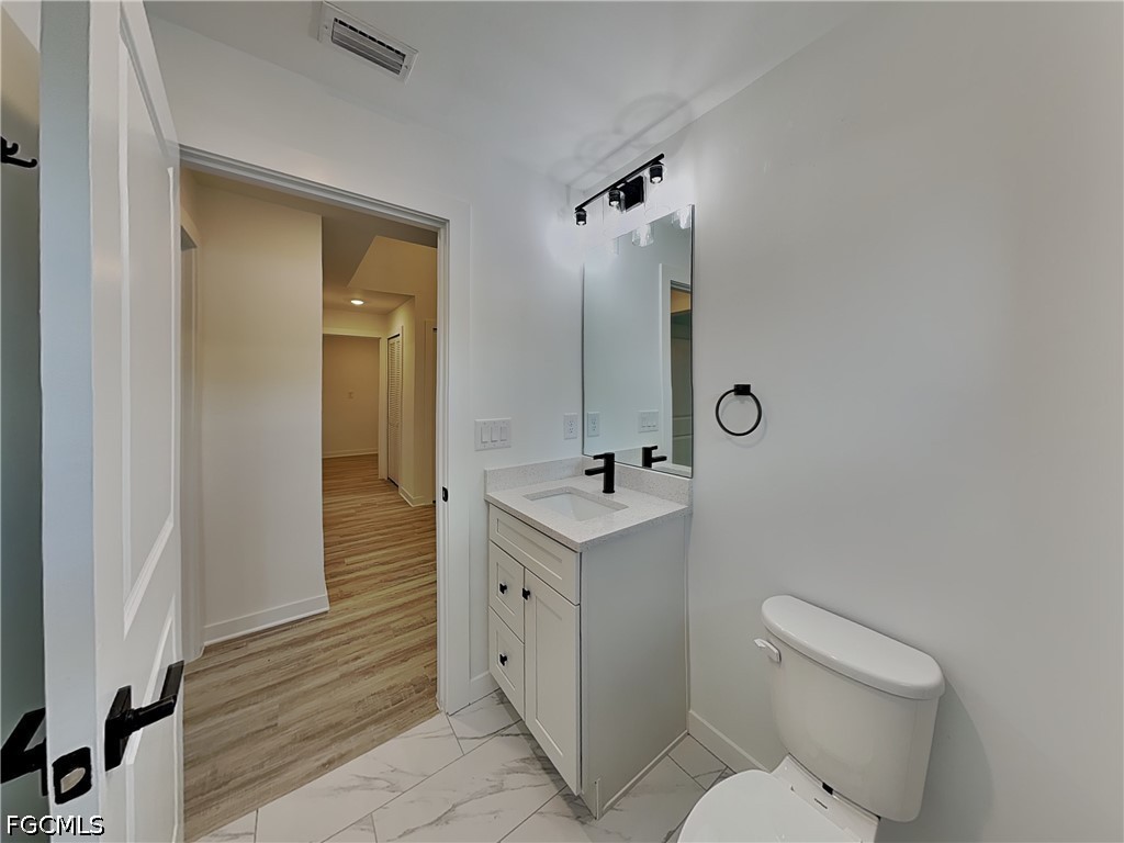 3201 23rd Street Southwest Lehigh Acres, FL 33976 - Photo 13 of 15 a bathroom with a toilet sink and mirror
