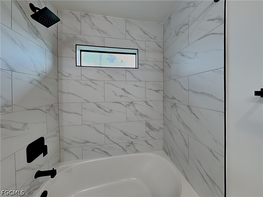 3201 23rd Street Southwest Lehigh Acres, FL 33976 - Photo 14 of 15 a bathroom with a bathtub and a shower