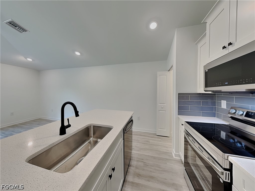 3201 23rd Street Southwest Lehigh Acres, FL 33976 - Photo 3 of 15 a kitchen with a sink and a stove top oven