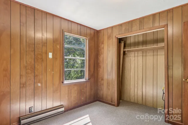 a view of an empty room with wooden walls and windows