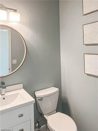 a white toilet sitting next to a bathroom sink