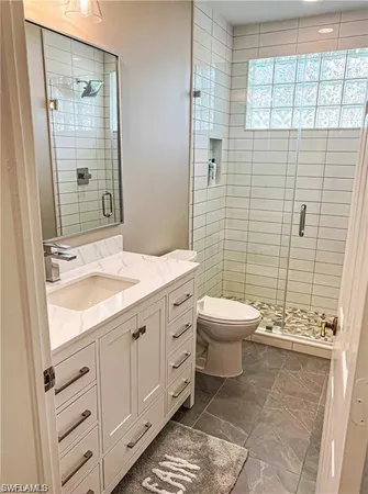 a bathroom with a granite countertop sink toilet and shower