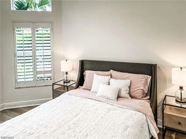 a large bed sitting in a bedroom next to a window
