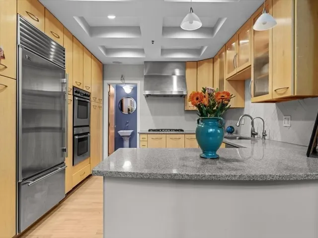 a kitchen with stainless steel appliances granite countertop a sink and a refrigerator