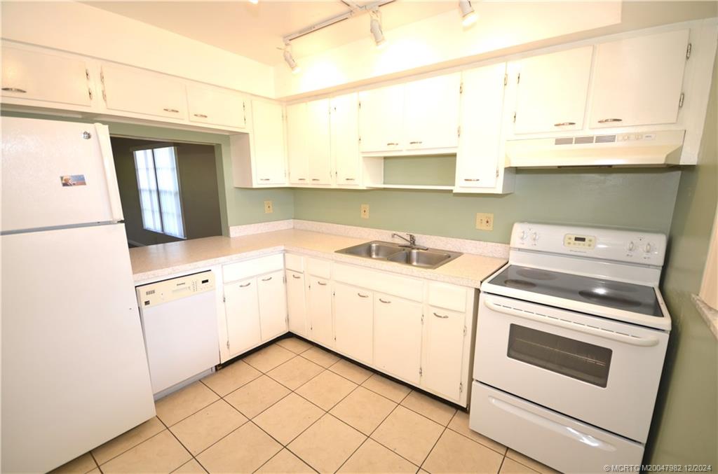 1900 South Kanner Highway, Unit 7205 Stuart, FL 34994 - Photo 4 of 25 a kitchen with a white cabinets and white appliances
