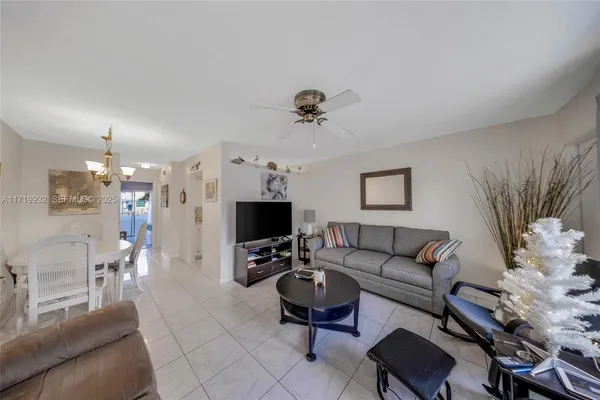 a living room with furniture a chandelier and a flat screen tv