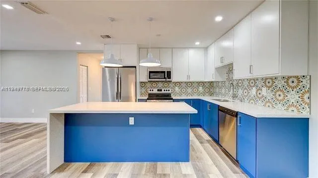 a kitchen with kitchen island granite countertop a sink stove and refrigerator