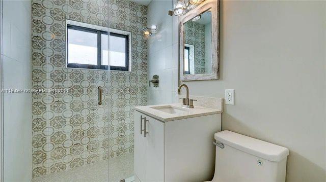 1050 Southwest 11th Street, Unit 1052 Miami, FL 33129 - Photo 6 of 10 a bathroom with a sink toilet and mirror