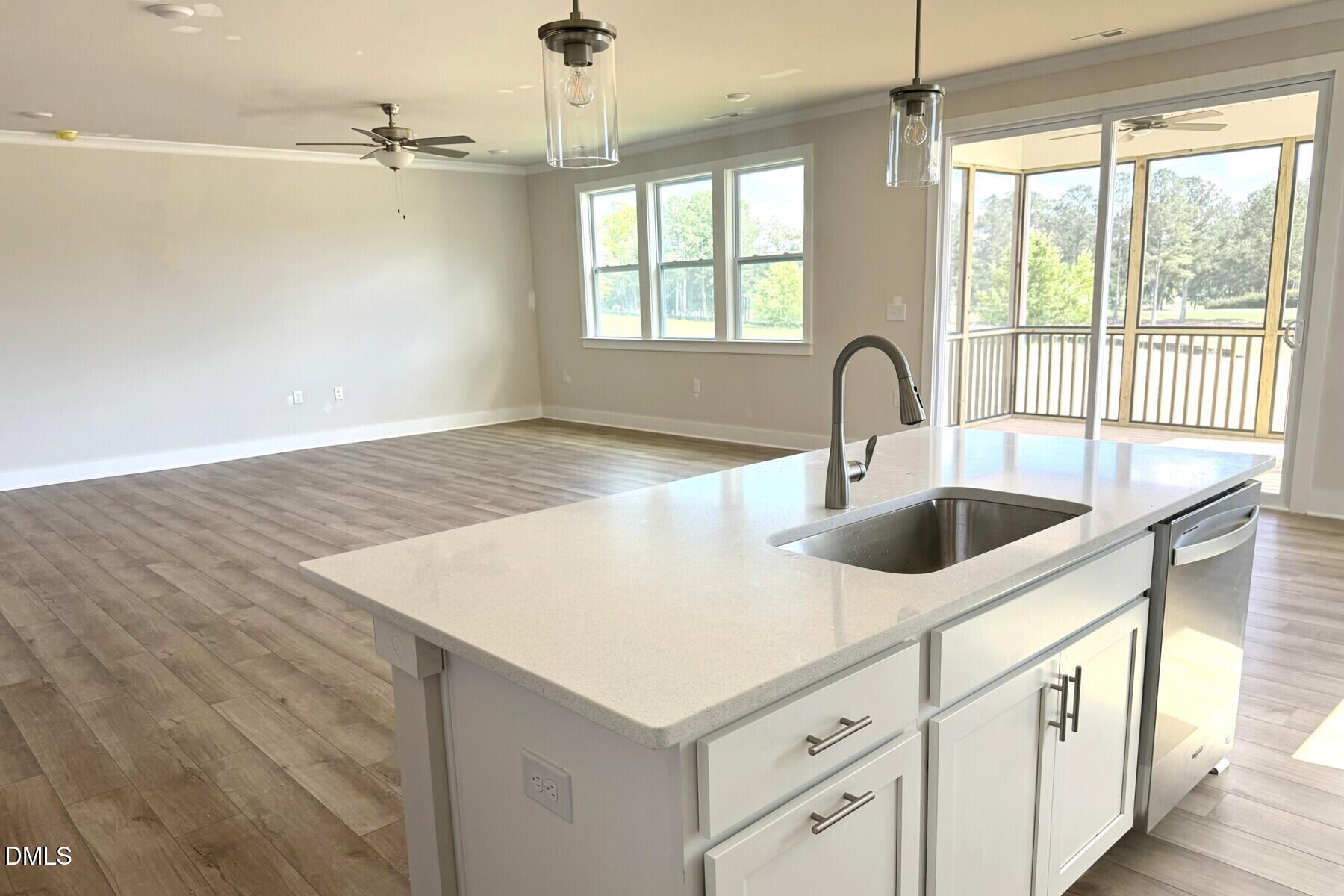 385 Denali Drive Angier, NC 27501 - Photo 11 of 19 a kitchen with a sink dishwasher a stove and white countertops with wooden floor